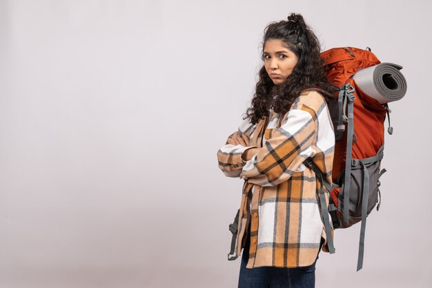 Vista frontal joven mujer yendo de excursión con mochila sobre fondo blanco campus turístico vacaciones montaña viaje bosque