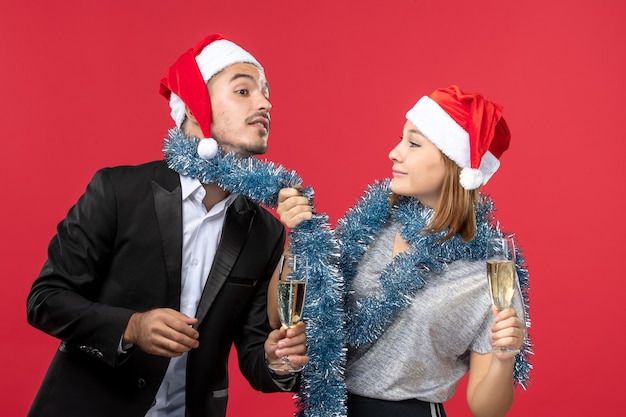 Vista frontal joven pareja celebrando el año nuevo en el escritorio rojo amor bebida de fiesta de navidad