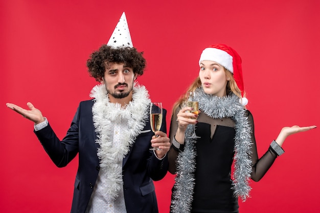 Vista frontal joven pareja celebrando el año nuevo en el escritorio rojo foto amor de navidad