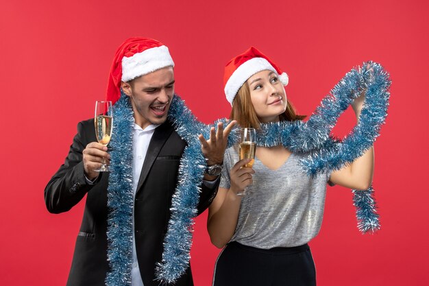 Vista frontal joven pareja celebrando el año nuevo en el escritorio rojo vacaciones amor navidad