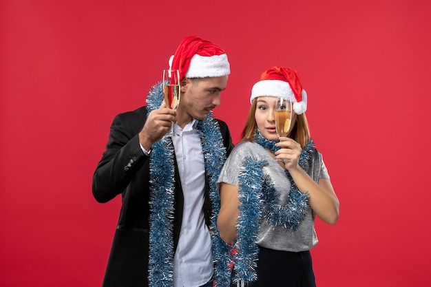 Vista frontal joven pareja celebrando el año nuevo en la fiesta de escritorio rojo amor navidad