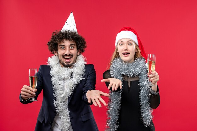 Vista frontal joven pareja celebrando el año nuevo en la fiesta de escritorio rojo amor navidad