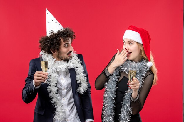 Foto gratuita vista frontal de la joven pareja celebrando el año nuevo en la fiesta de navidad de amor de vacaciones de escritorio rojo