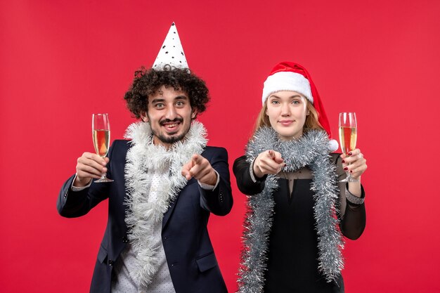 Vista frontal joven pareja celebrando el año nuevo en la pared roja amor fiesta de navidad