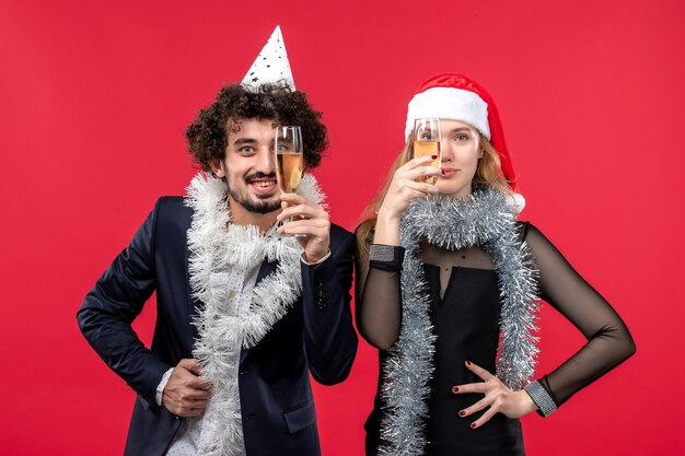 Vista frontal joven pareja celebrando el año nuevo en la pared roja fiesta de amor de navidad