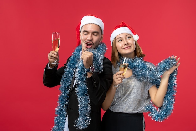Vista frontal joven pareja celebrando el año nuevo en el piso rojo vacaciones amor navidad