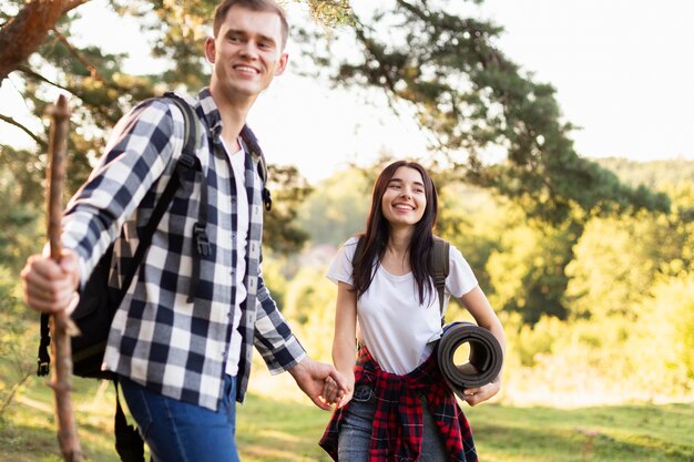 Vista frontal de la joven pareja divirtiéndose al aire libre