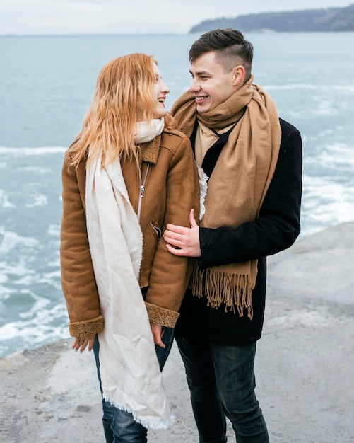 Foto gratuita vista frontal de la joven pareja en invierno en la playa