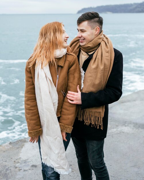Vista frontal de la joven pareja en invierno en la playa