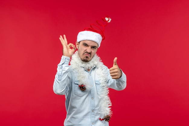 Foto gratuita vista frontal del joven preparándose para el año nuevo en la pared roja