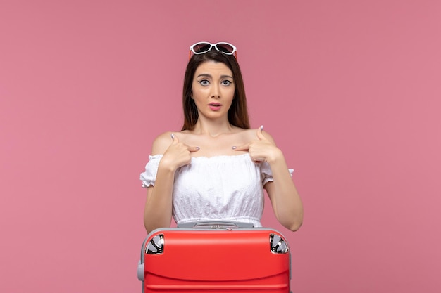 Vista frontal joven preparándose para las vacaciones con su bolso sobre fondo rosa viaje viaje viaje femenino mar en el extranjero