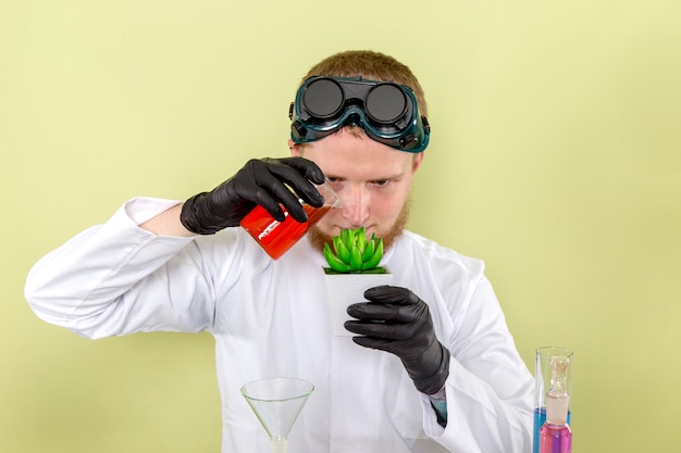 Vista frontal joven químico haciendo algún experimento con planta
