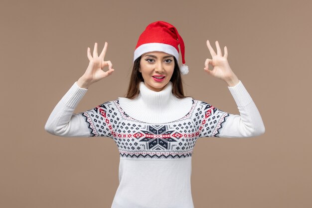 Vista frontal joven solo sonriendo sobre fondo marrón emoción navidad año nuevo