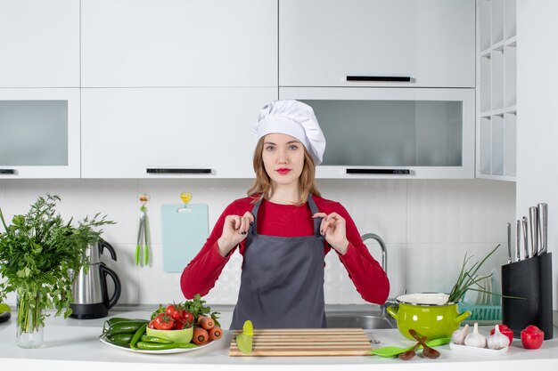 Vista frontal joven con sombrero de cocinero sosteniendo su delantal