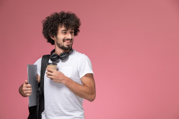 Vista frontal joven sonriendo y sosteniendo café