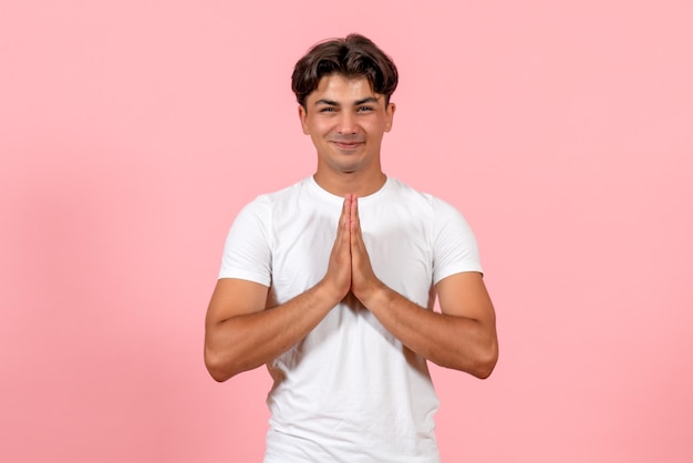 Vista frontal joven sonriente en camiseta blanca sobre fondo rosa