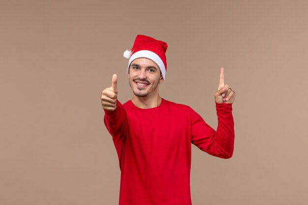 Vista frontal joven sonriente sobre fondo marrón Navidad emoción vacaciones