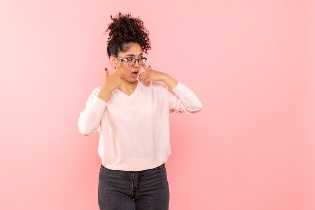 Vista frontal de la joven sorprendida en la pared rosa