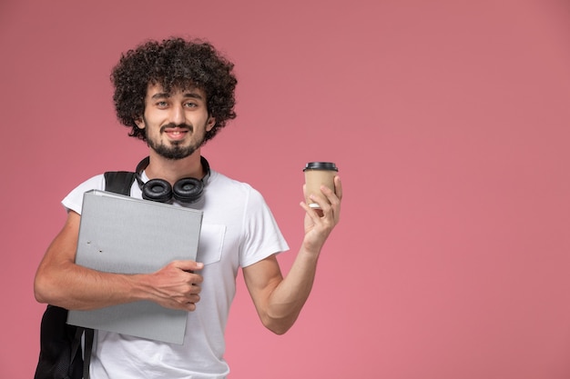 Vista frontal joven sosteniendo binder y taza de café