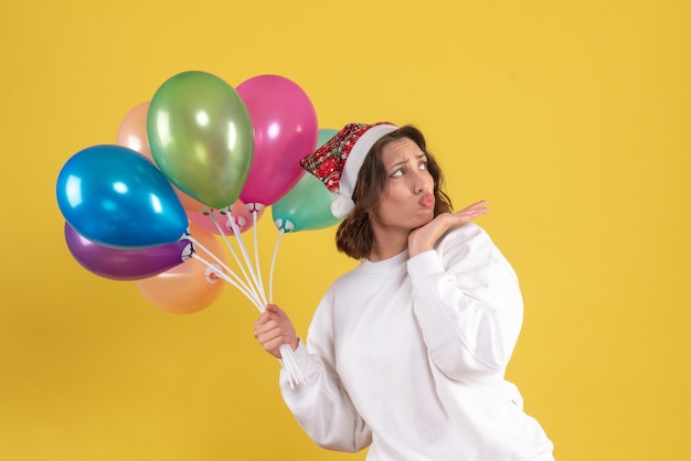 Foto gratuita vista frontal joven sosteniendo globos de colores en amarillo