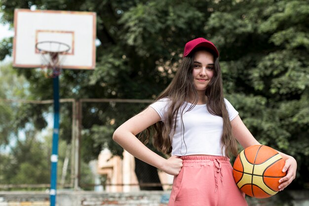 Vista frontal joven sosteniendo una pelota de baloncesto