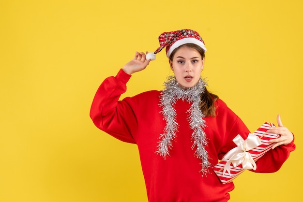 Foto gratuita vista frontal joven con suéter rojo con regalo y su gorro de santa