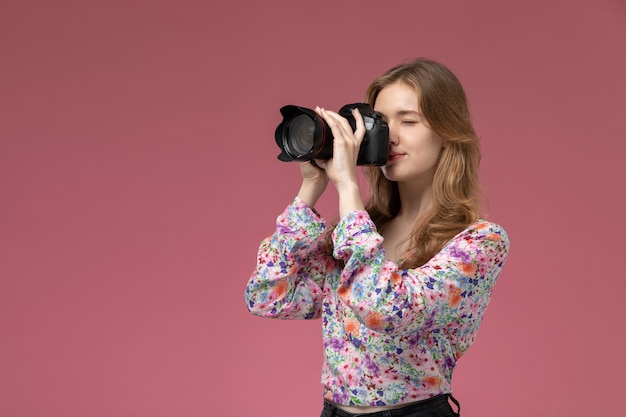 Foto gratuita vista frontal joven tomando una foto con su cámara fotográfica