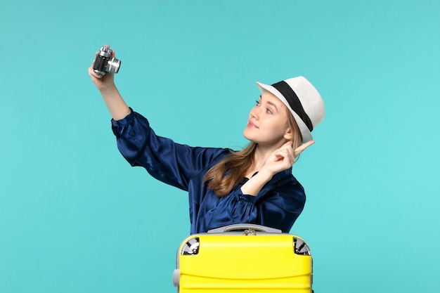 Foto gratuita vista frontal joven tomando fotos con cámara sobre fondo azul mujer viaje mar viaje avión de viaje