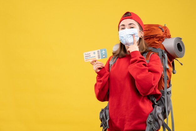 Foto gratuita vista frontal joven viajera con mochila y máscara con boleto