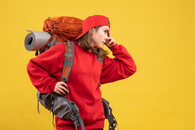 Vista frontal joven viajera con mochila poniendo la mano en la cara