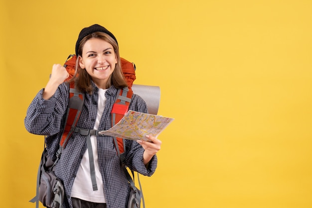 Foto gratuita vista frontal del joven viajero feliz con mochila con mapa