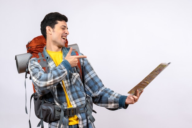 Vista frontal joven viajero con mochila apuntando al lugar en el mapa