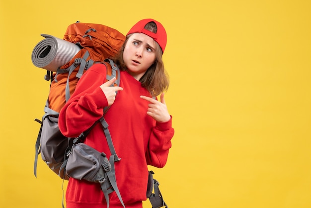 Foto gratuita vista frontal joven viajero mujer en mochila roja apuntando a sí misma