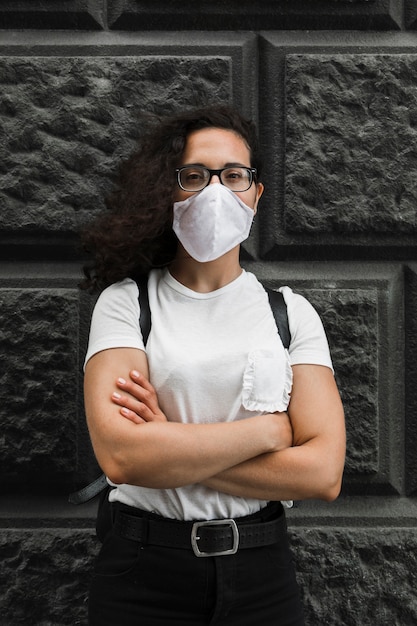 Vista frontal joven vistiendo una máscara médica al aire libre