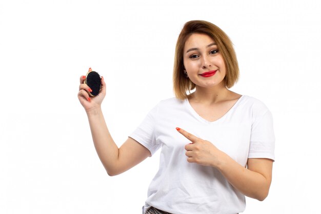 Una vista frontal jovencita con camisa blanca y pantalones modernos ligeros con pequeño cepillo negro sobre el blanco