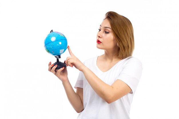 Una vista frontal jovencita en camiseta blanca con globo pequeño en el blanco