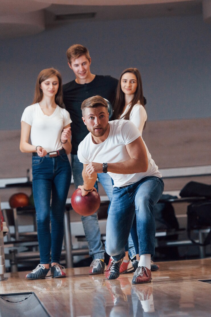 Foto gratuito vista frontal. jóvenes amigos alegres se divierten en el club de bolos en sus fines de semana