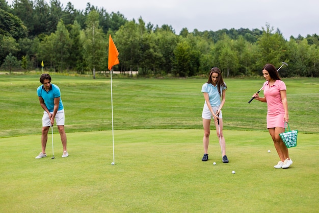Vista frontal de jóvenes golfistas jugando