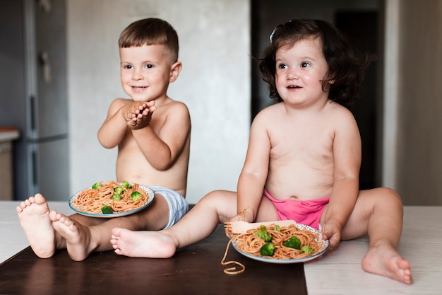 Foto gratuita vista frontal jóvenes hermanos en la cocina