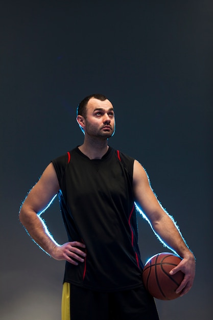 Vista frontal del jugador de baloncesto con balón y espacio de copia