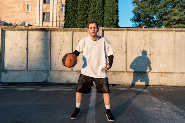 Vista frontal del jugador de baloncesto en cancha urbana