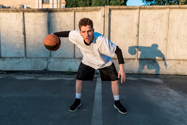 Vista frontal del jugador de baloncesto en cancha urbana