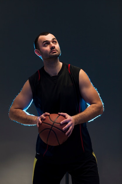 Vista frontal del jugador de baloncesto sosteniendo la pelota con ambas manos