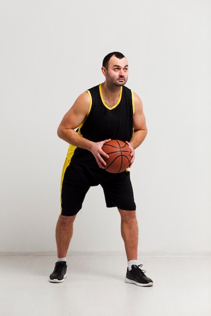 Vista frontal del jugador masculino con baloncesto