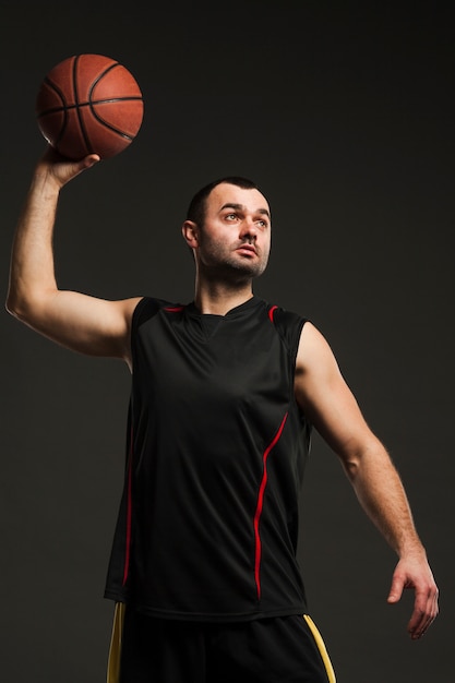 Vista frontal del jugador masculino lanzando baloncesto