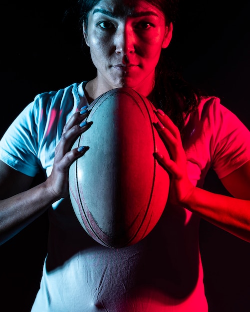 Foto gratuita vista frontal del jugador de rugby femenino sosteniendo la bola