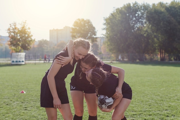 Vista frontal de jugadores de fútbol femenino abrazando