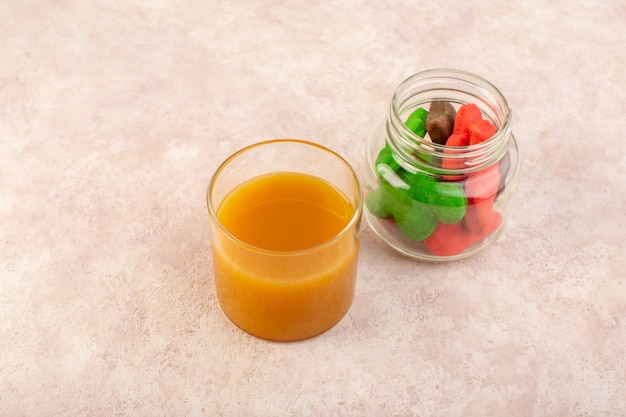 Vista frontal de jugo de durazno fresco dulce y delicioso con galletas de colores dentro de lata