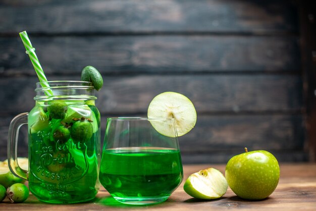 Vista frontal jugo de feijoa verde con manzanas frescas y feijoas en barra oscura cóctel de fotos en color de frutas