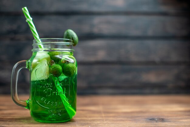 Vista frontal jugo fresco de feijoa dentro de lata con pajita en barra oscura foto de frutas cóctel bebida de color baya espacio libre